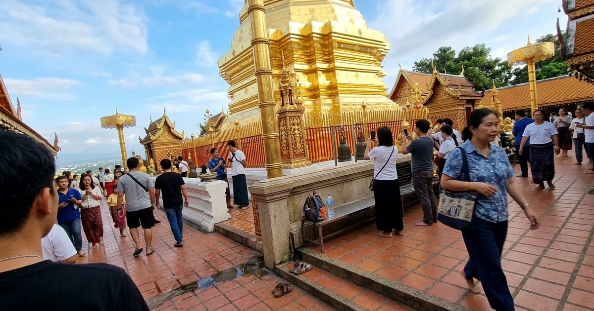 The golden chedi of Wat Phra That Doi Suthep with visitors on the terrace