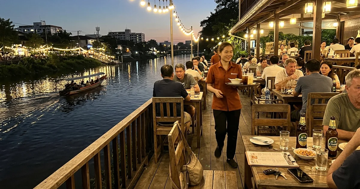 The Ping River bank in Chiang Mai with riverside restaurants at golden hour